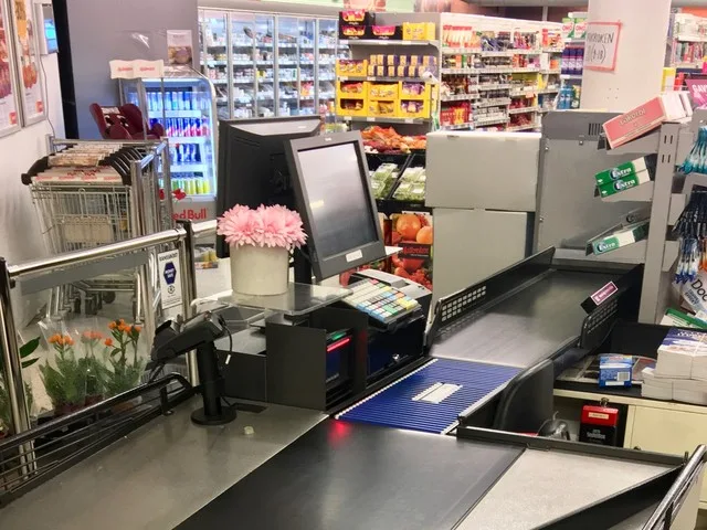 Pénztárgép és árufeltöltés az élelmiszerbolt kasszasorában